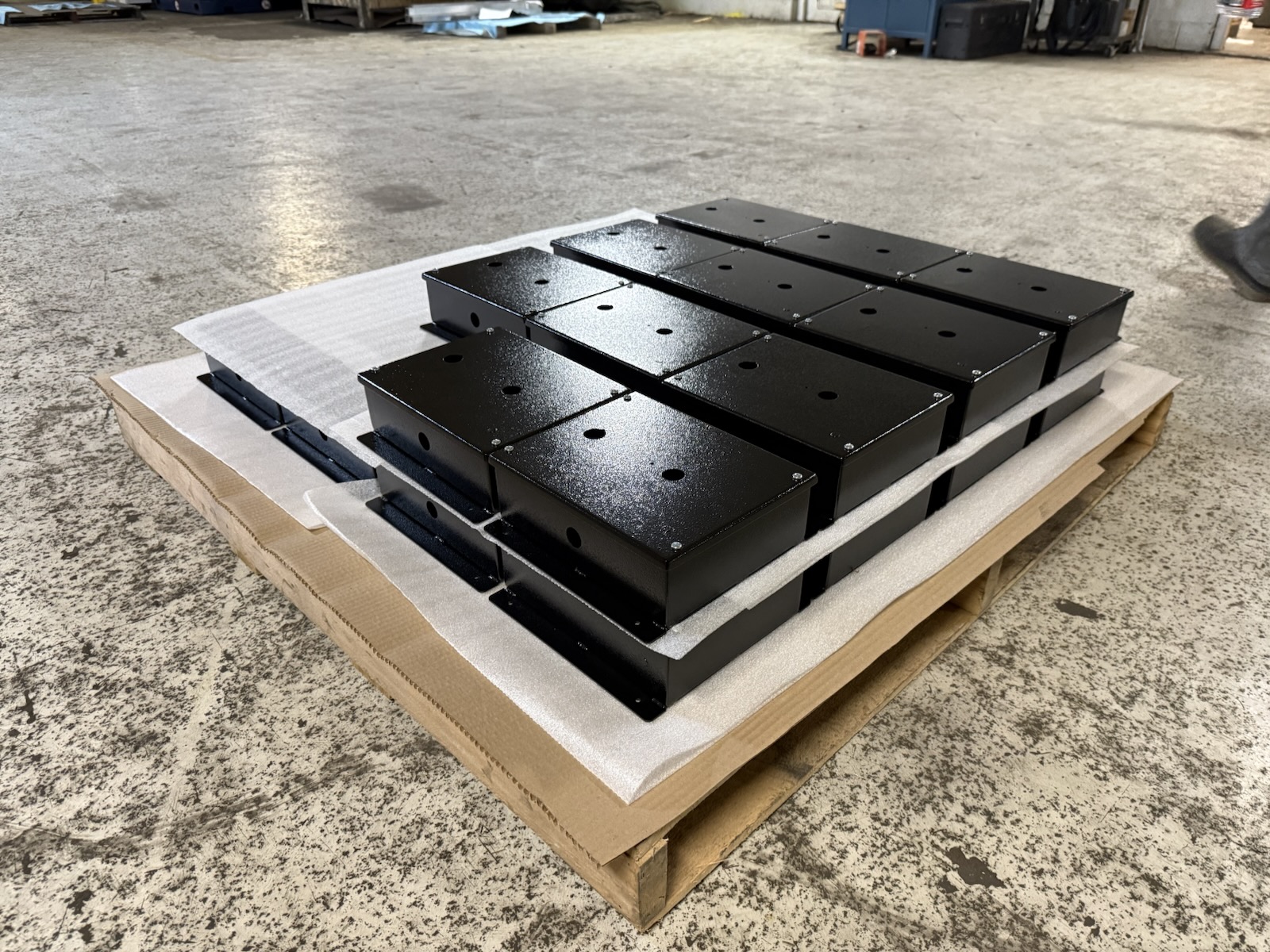 Black powder coated controller enclosures on pallet